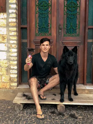 Foto de Byron con su perro y el cepillo lleno de pelo